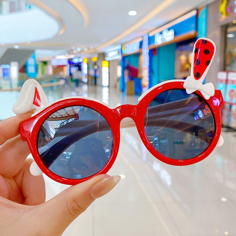 Girls' outdoor UV protection sunglasses featuring a fun rabbit cartoon design in pastel pink.