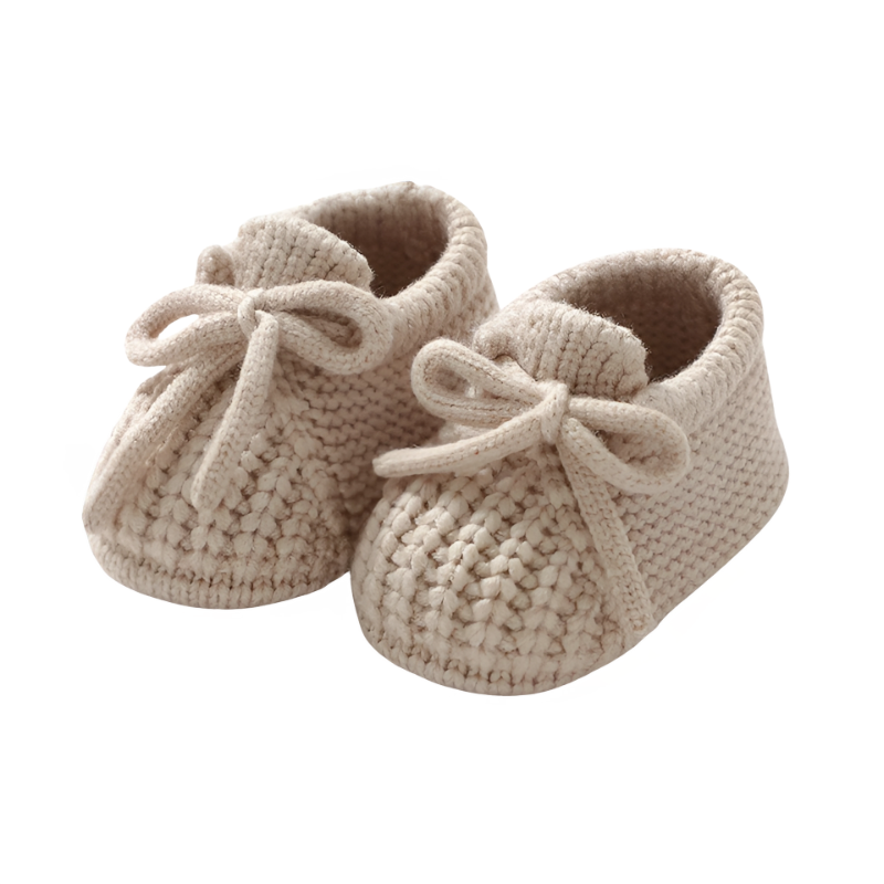 Pink knitted baby booties with a delicate button detail, ideal for a baby shower gift.