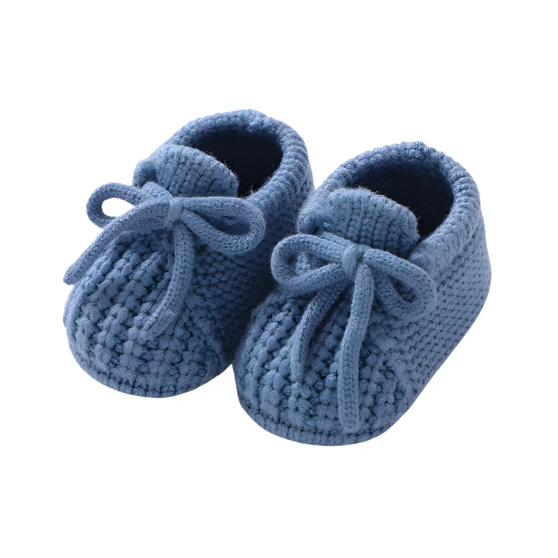 Newborn essentials: white knitted baby booties, offering a cozy and secure fit for tiny feet.