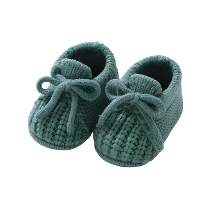 Soft green knitted baby booties, perfect for keeping infant feet warm and snug.