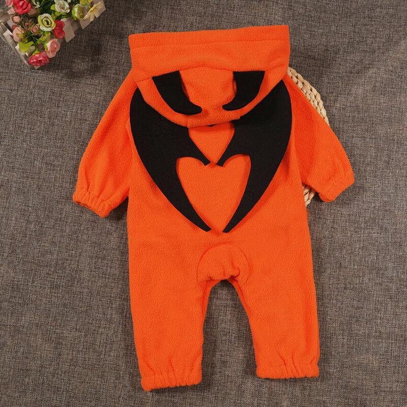 Baby in a plush orange pumpkin costume onesie, ready for their first Halloween.