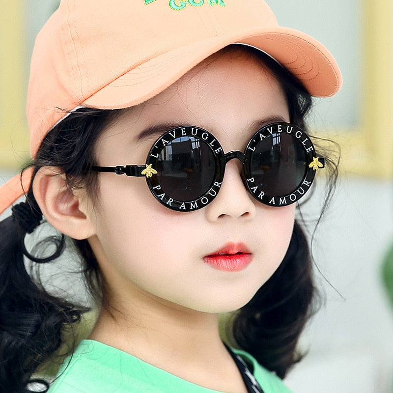Adorable kids' pink round frame sunglasses providing UV protection for stylish outdoor play.