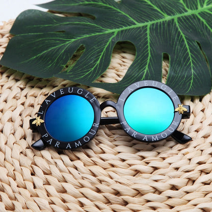 Kids' fashionable round frame sunglasses, offering full UV protection for all summer activities.