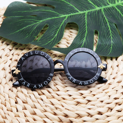 Pack of kids' round frame UV protection sunglasses in assorted colors, ideal for family fun.