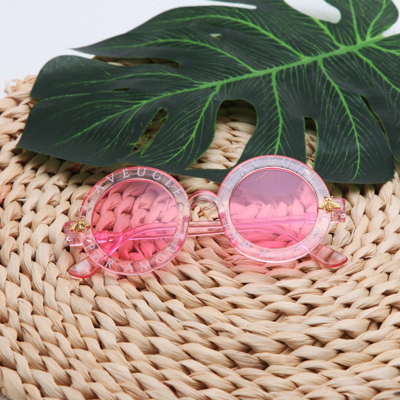 Girls' round frame UV protection sunglasses in a vibrant orange, ideal for summer fashion.
