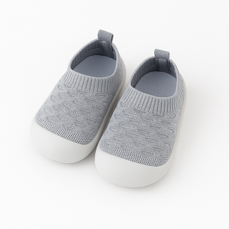 Close-up of a knit barefoot-feel first walking shoe, soft and flexible.
