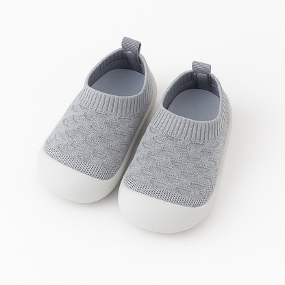 Close-up of a knit barefoot-feel first walking shoe, soft and flexible.