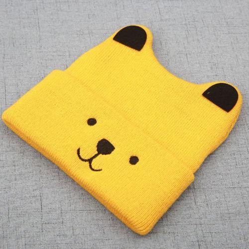 Side profile of a baby wearing a knitted bear cub hat, adding a cute touch to their outfit.