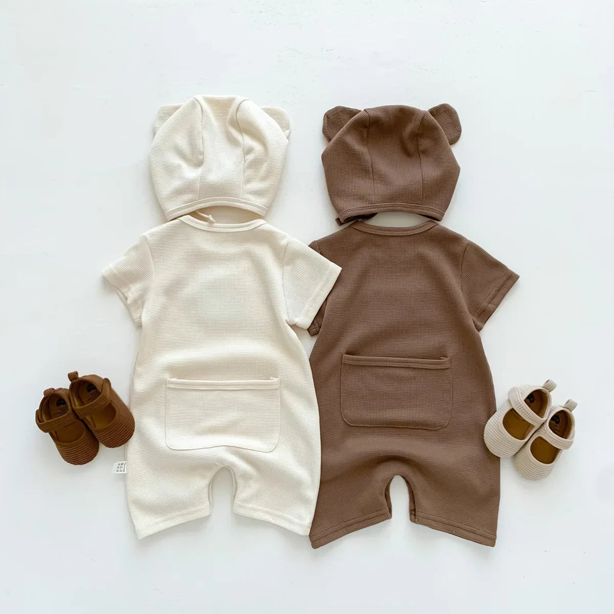 Two newborn bear rompers in different sizes, perfect for baby clothing collections.