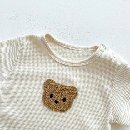 Close-up of the breathable cotton fabric of the newborn bear romper, short sleeve.