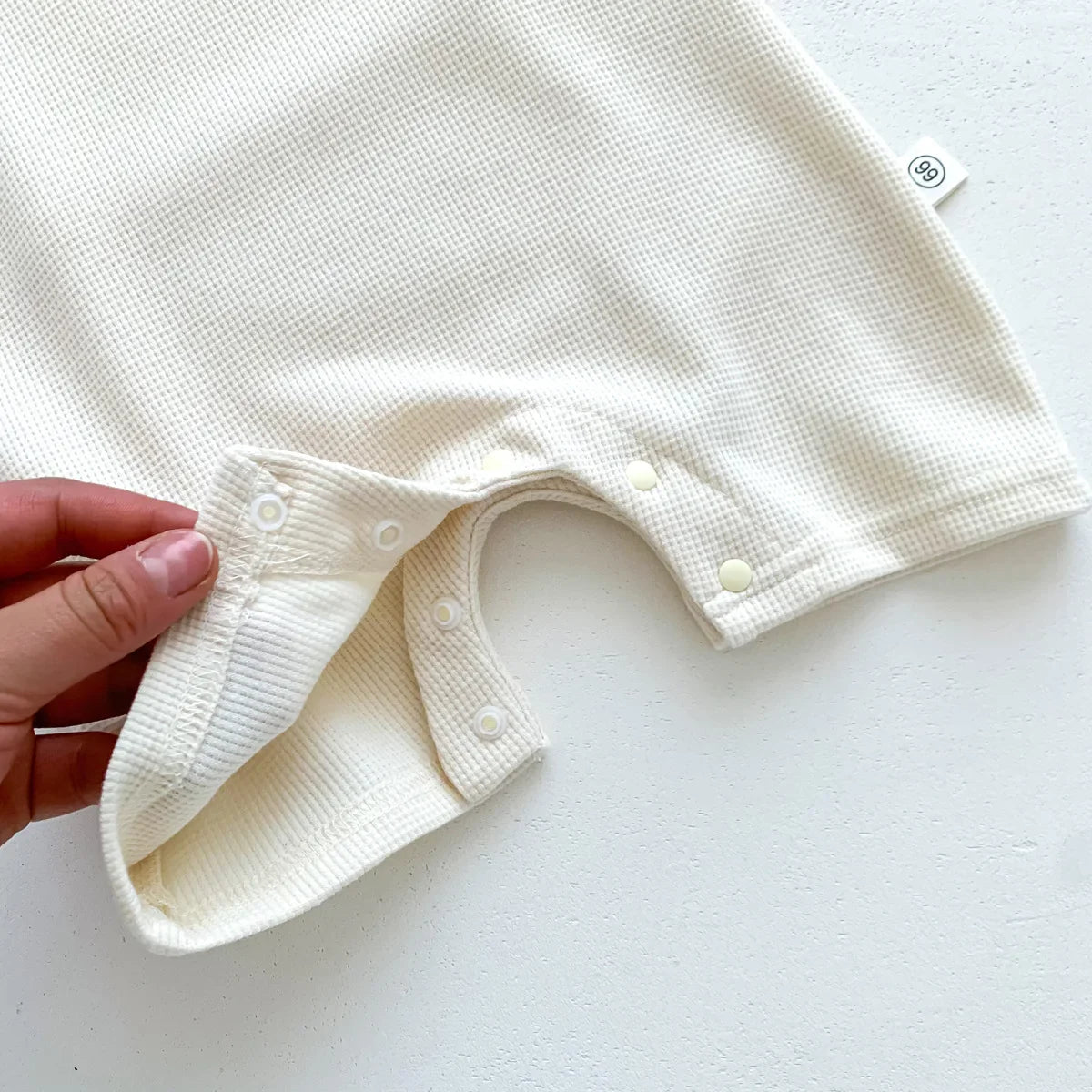 Detail of the short sleeves on the cotton bear romper, ideal for warm weather.