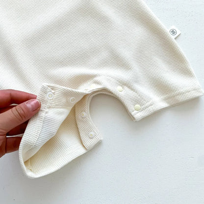 Detail of the short sleeves on the cotton bear romper, ideal for warm weather.