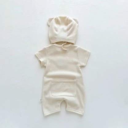 Happy newborn in a cute bear romper, capturing the joy of infant fashion.