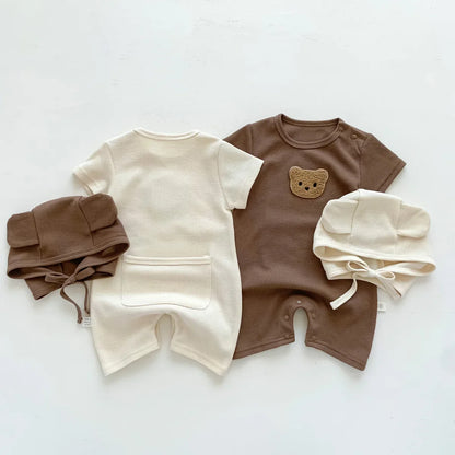 Close-up of a soft cotton newborn romper with cute bear ears on the hood, infant outfit.