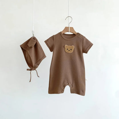 Detail of the bear face embroidery on a soft cotton newborn romper.
