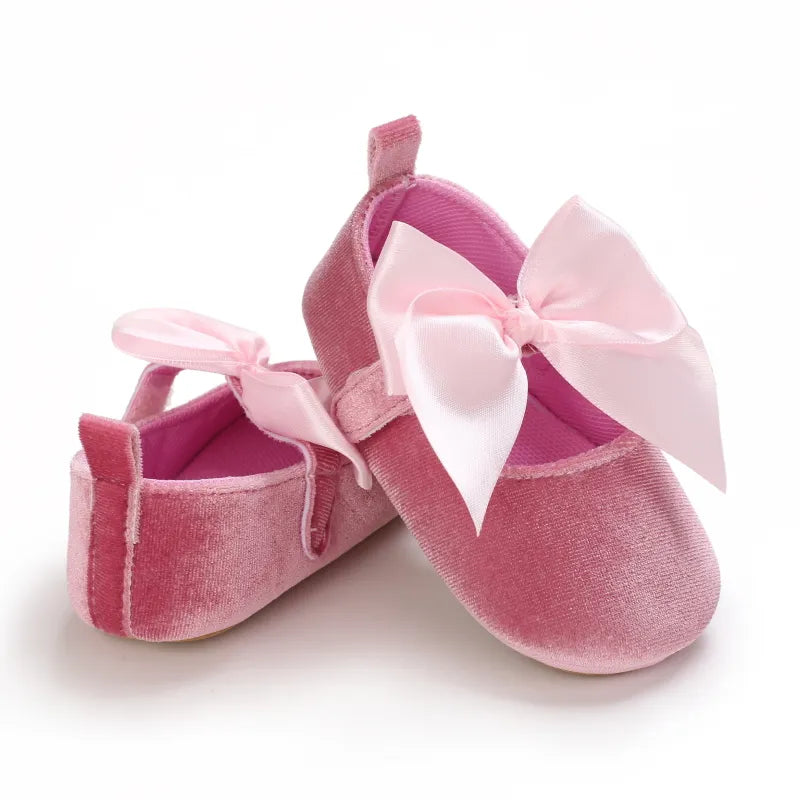 Detail of the soft cotton fabric on a blue baby girl bow flat shoe, infant first walker