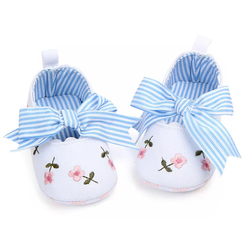Stylish white lace floral baby girl's first walker shoes, a lovely addition to any infant's wardrobe.
