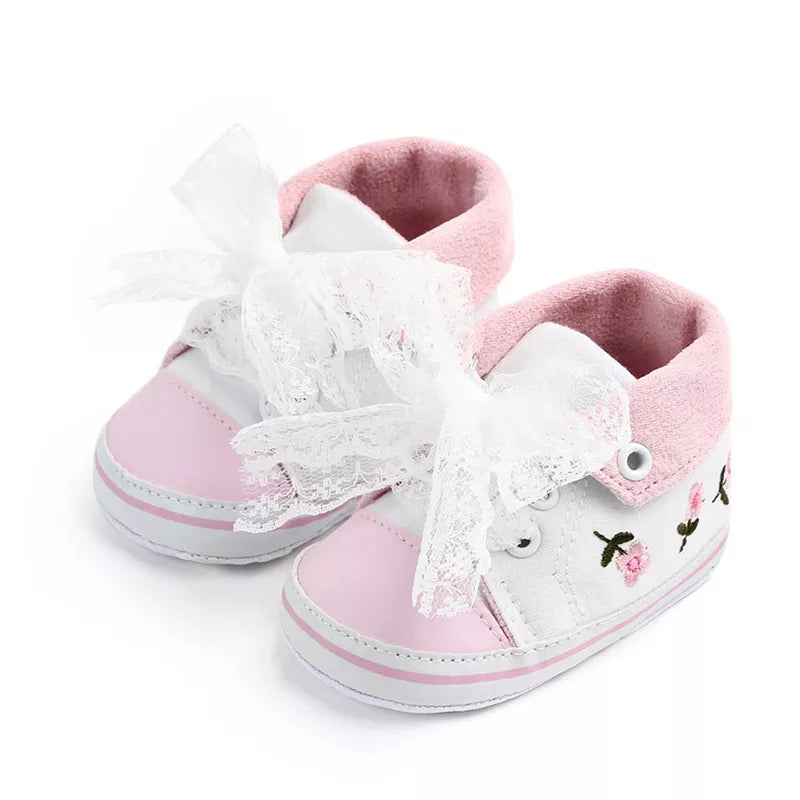 Baby girl's first walker shoes, white with beautiful lace floral patterns, made from soft cotton for comfort.