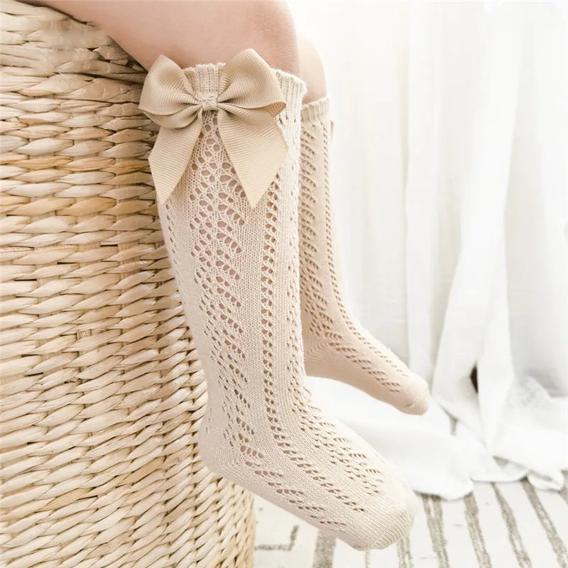Model showcasing knee-high bow socks, ideal for children's fashion.