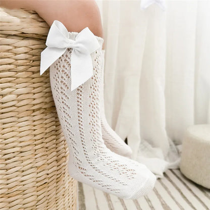 Cotton blend blue knee-high socks with charming bows, durable for kids.