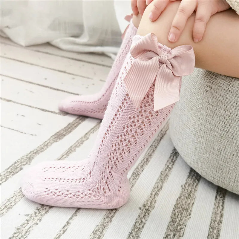 Variety of knee-high bow socks displayed, suitable for toddler apparel.