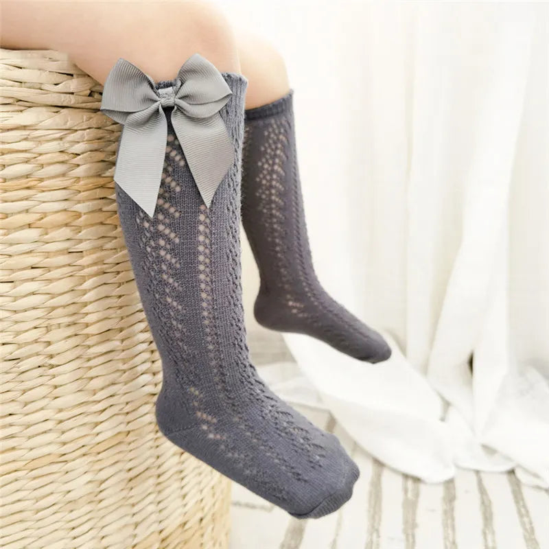 Cute bow detail on knee-high socks, essential baby accessories.