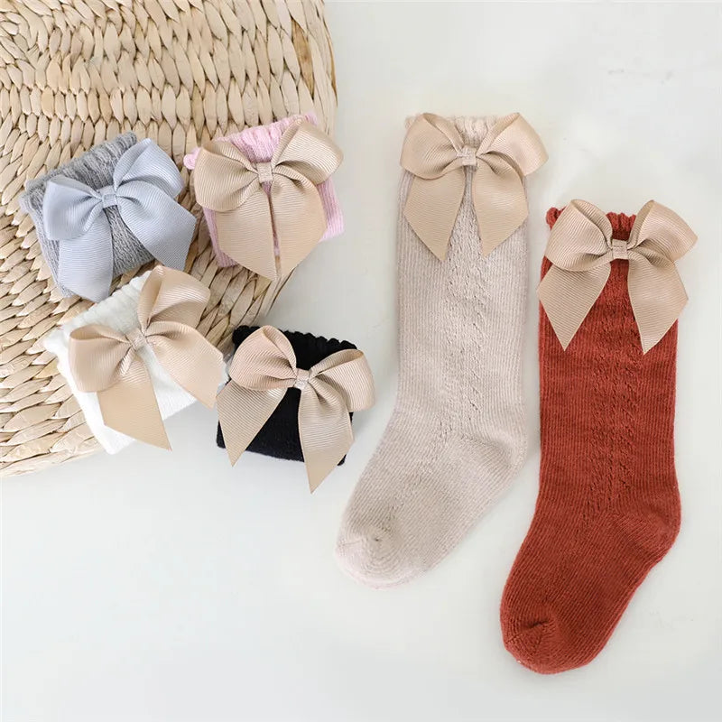 Toddler's red bow knee-high socks, perfect for fashion-forward little ones.