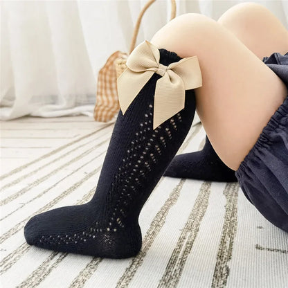 Set of multi-colored bow knee-high socks for diverse kids' outfits.