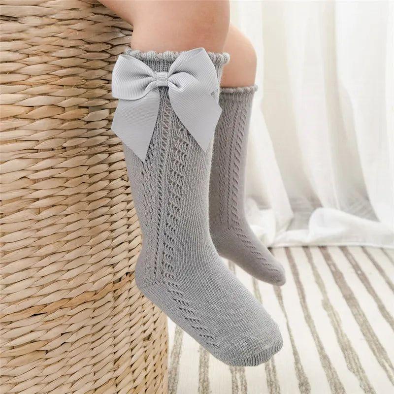 Baby accessories: yellow knee-high socks with an elegant bow design.