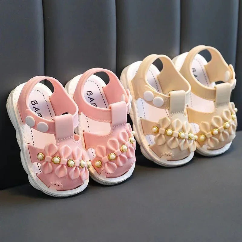 Comfortable pink bow summer sandals for baby girls on a white background.