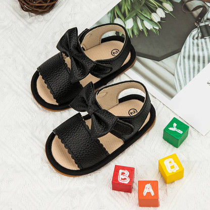 Close-up of pink PU leather baby sandals featuring a sweet bowknot design
