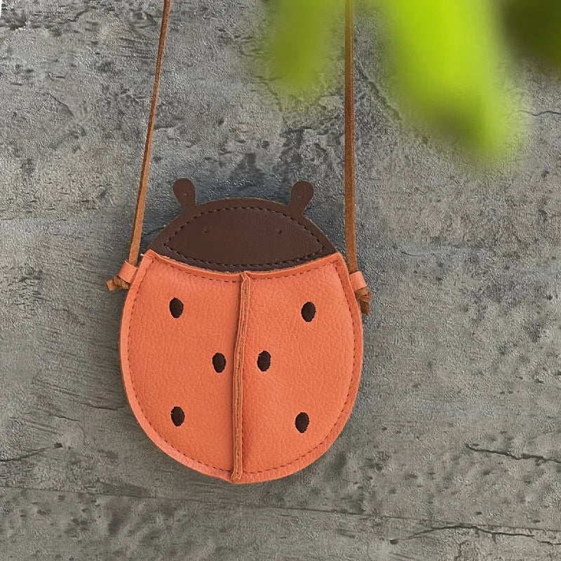 Various cartoon crossbody bags for toddler girls displayed, PU leather children accessories