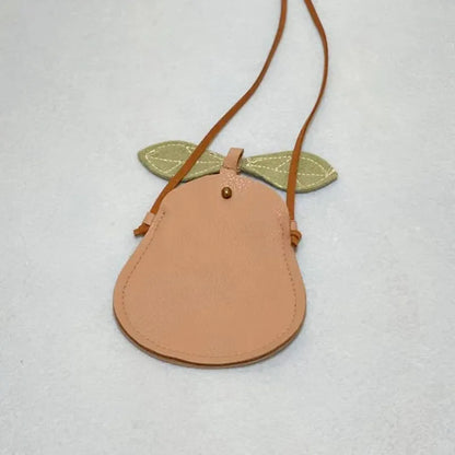 Stylized shot of a toddler girl's yellow cartoon cat crossbody bag with play items