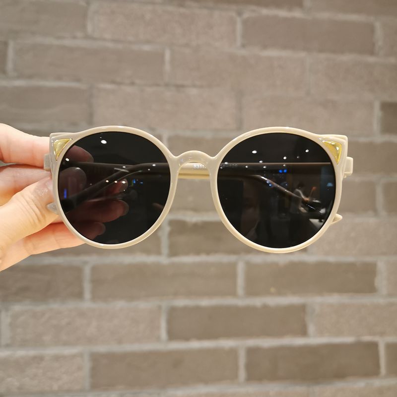 Child wearing pink cartoon cat eye sunglasses, UV protection, stylish kids eyewear, outdoor fashion