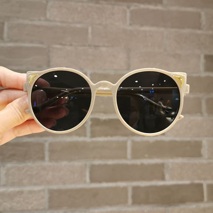 Child wearing pink cartoon cat eye sunglasses, UV protection, stylish kids eyewear, outdoor fashion