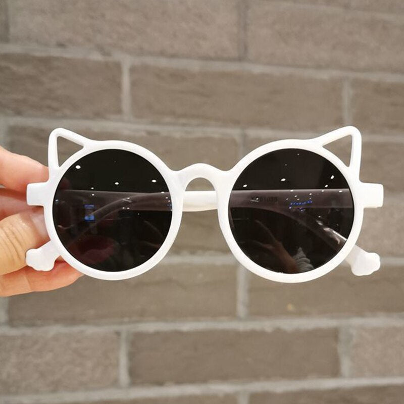 Close-up of pink cartoon cat eye sunglasses, detail of cute design, UV protection for girls