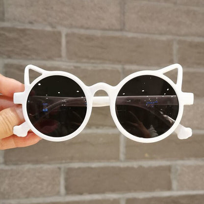 Close-up of pink cartoon cat eye sunglasses, detail of cute design, UV protection for girls