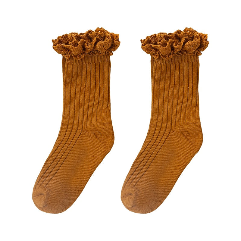 Model wearing white cotton ruffle mid-calf socks, showcasing their fit for a comfortable baby outfit.