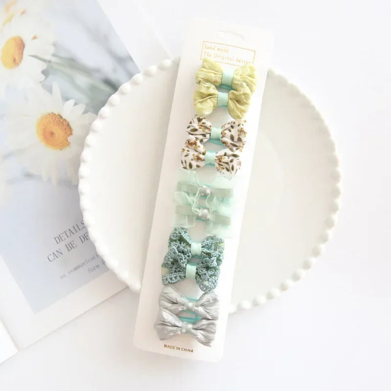 Delicate white fabric hair bow with clip, perfect for special occasions or daily baby hair styling.