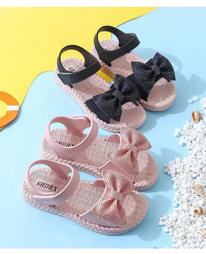 Detail of the bow embellishment on a pink girls' summer sandal, cute and secure