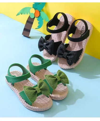 Girl's foot in a black bow sandal, demonstrating comfortable fit and stylish look