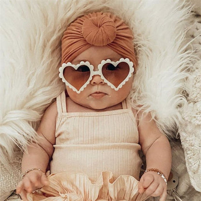 Adorable pink heart-shaped sunglasses for girls, offering UV protection, front view