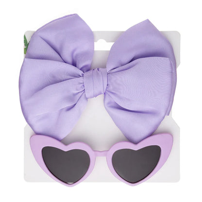 Vibrant pink heart sunglasses with UV protection and a soft, comfortable bow headband for kids.