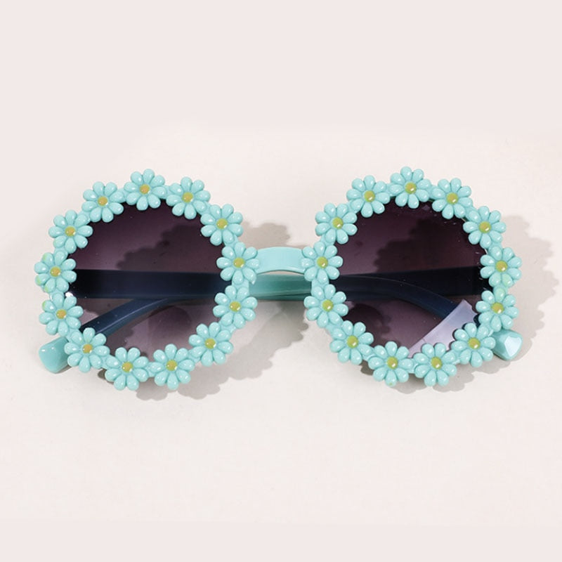 A display of multiple colored kids' UV protection sunglasses and bow headbands.