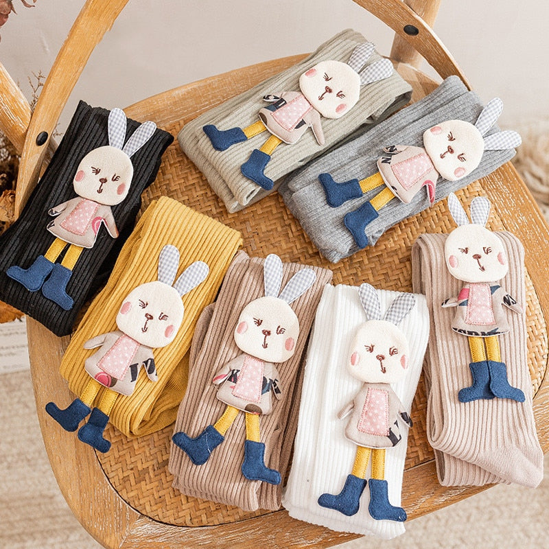 Adorable pink knitted girls' pantyhose with white cartoon rabbit pattern, soft and cozy for toddlers.