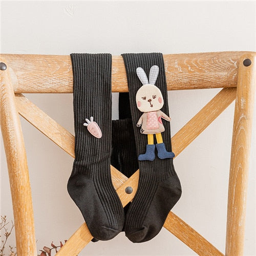 Girls' knitted pantyhose featuring a cute white rabbit design on a vibrant pink background, comfortable children's legwear.