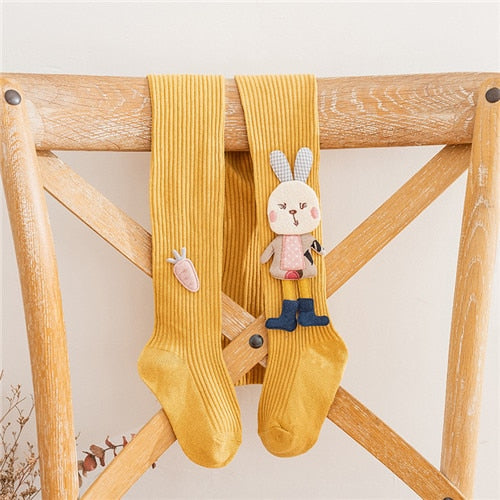 Close-up of soft knitted girls' tights in pink with charming embroidered white cartoon rabbit, ideal for kids.