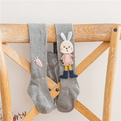 Toddler girls' pink knitted pantyhose with playful cartoon rabbit pattern, stylish and warm for children.