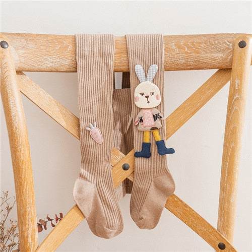 Fashionable pink knitted girls' tights showcasing a sweet white cartoon rabbit pattern, comfortable and durable.