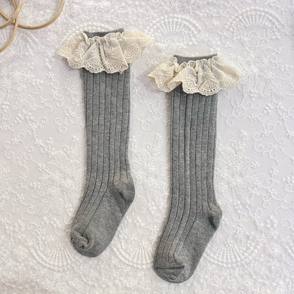 Cute yellow toddler girl socks featuring frilly lace cuffs and a small floral design